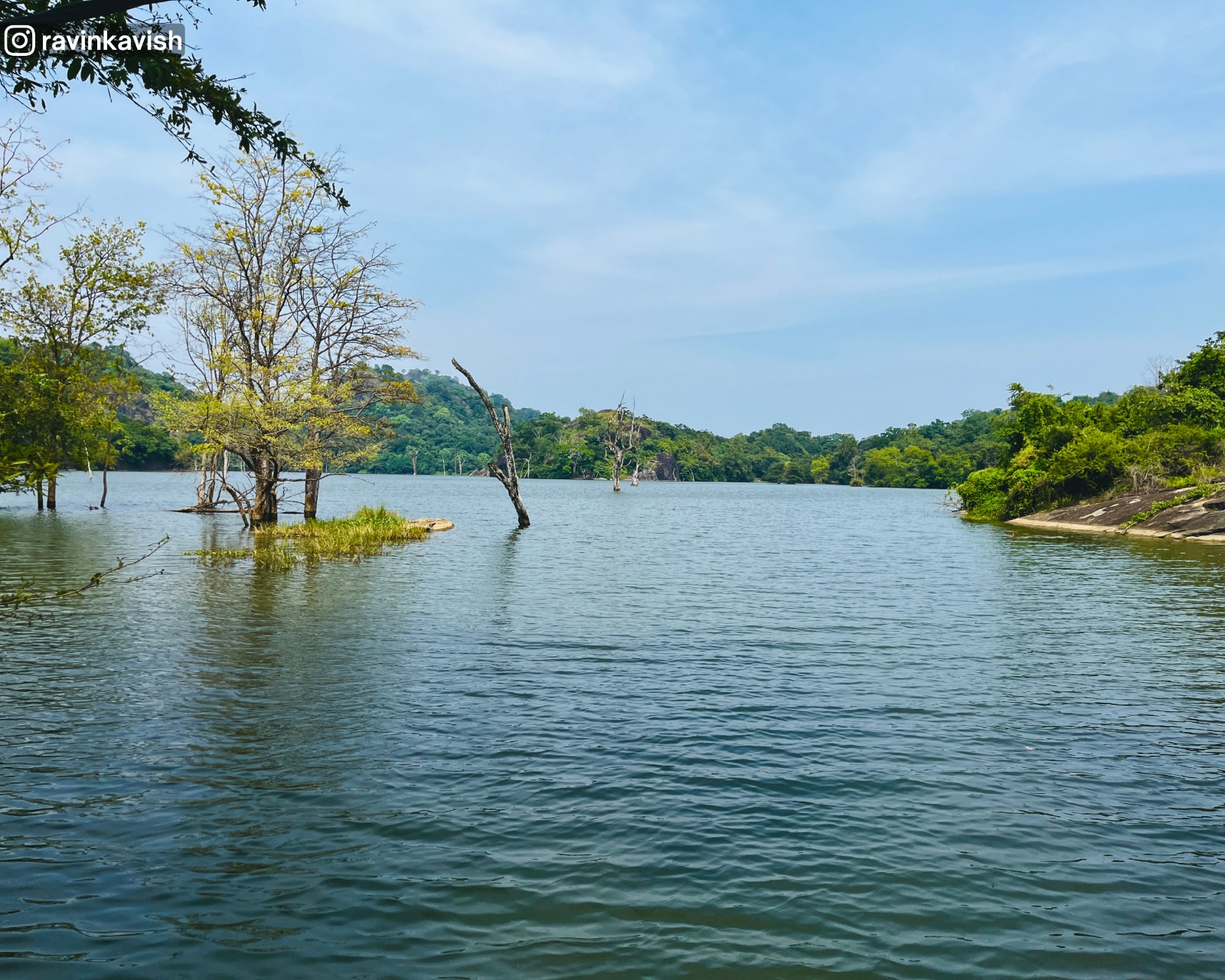 Buduruwagala Reservoir in Ella with water, surrounding hills, and trees growing in the water showcasing Sri Lankas scenic landscapes