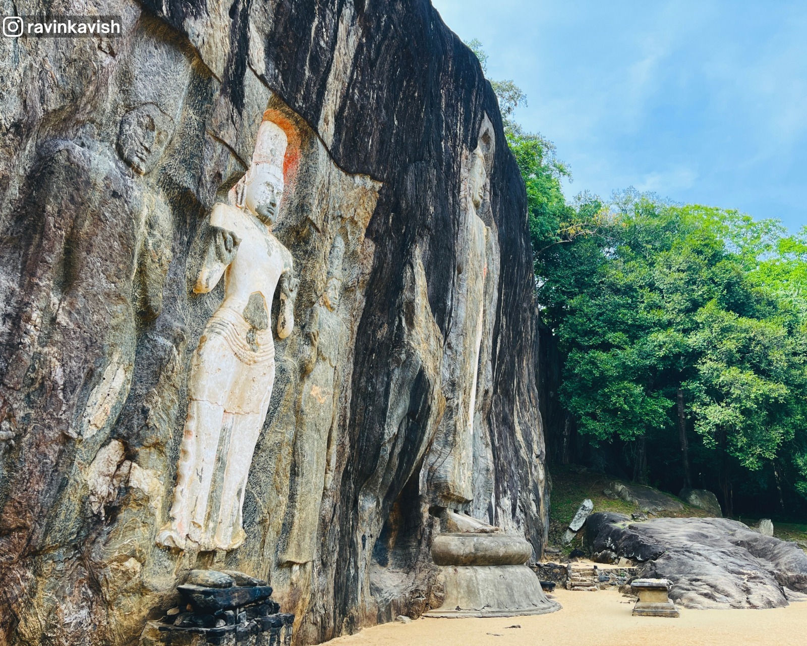 Buduruwagala rock carvings in Ella showing the entire rock face with a focus on the left-side figures