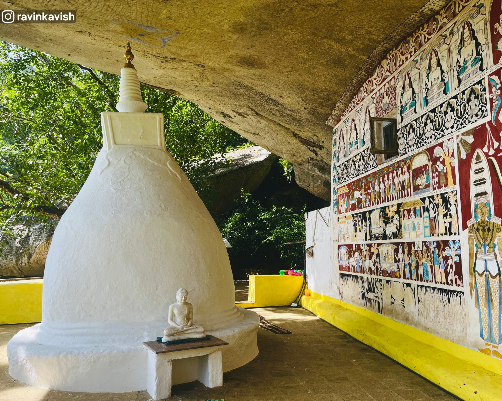 Close-up of the small stupa at the cave temple of Rakkiththa Kanda Rajamaha Viharaya showing the right-side mural wall and the rock-formed shelter above