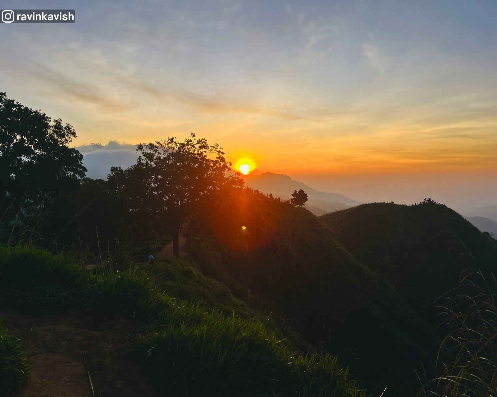 Early morning sunrise glow from Little Adams Peak in Ella over surrounding mountains and valleys showcasing Sri Lankas scenic hill country