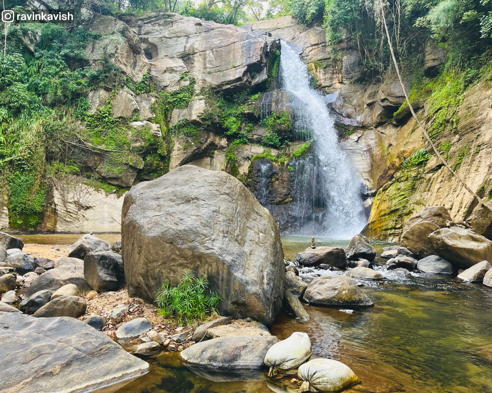 Ellewala Waterfall in Ella with a basin formed by rocks, scattered rocks around, and surrounding trees showcasing Sri Lankas natural beauty