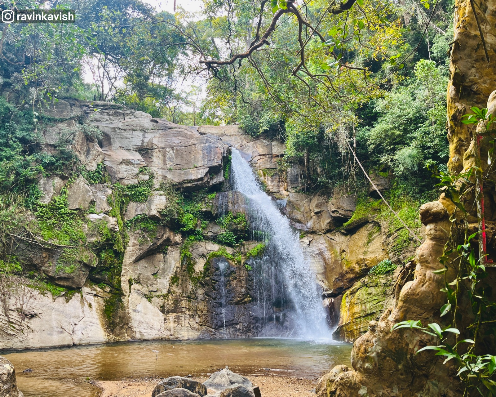 Ellewala Waterfall in Ella with surrounding rocks and a partially visible Kumbuk tree at the bank showcasing Sri Lankas natural landscapes
