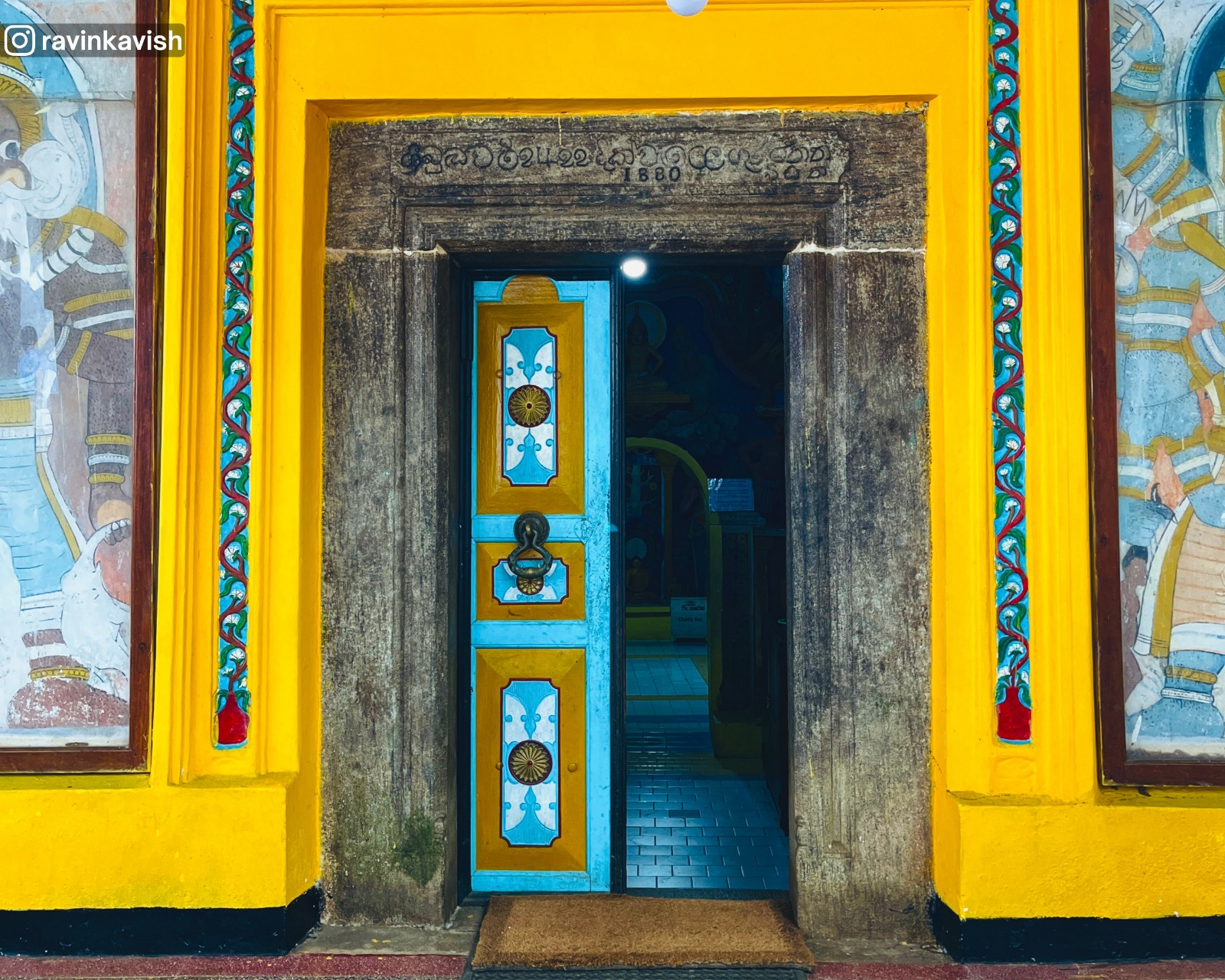 Entrance of the cave image house at Dowa Ancient Rock Temple, showing surrounding murals and decorative artwork