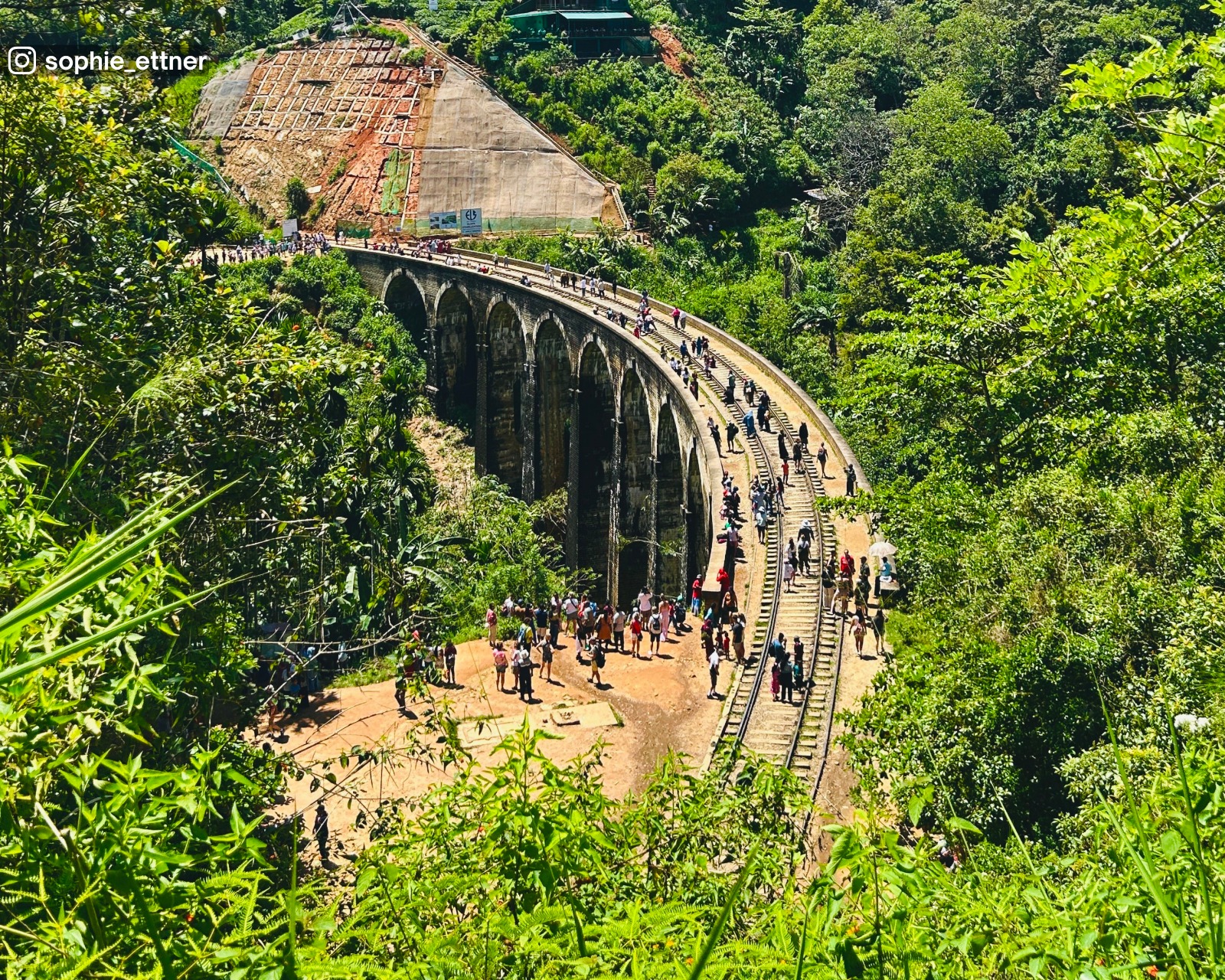 High-angle view of Nine Arch Bridge near the tunnel entrance, highlighting the stone arches and surrounding greenery