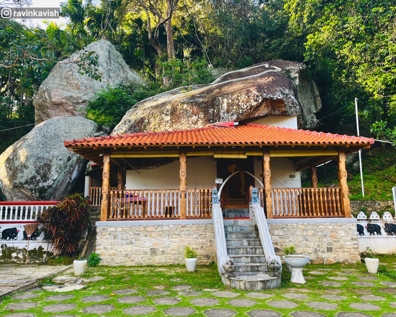Historic Ravana Royal Cave Temple image house with rock formations and forested surroundings near Ella, Sri Lanka