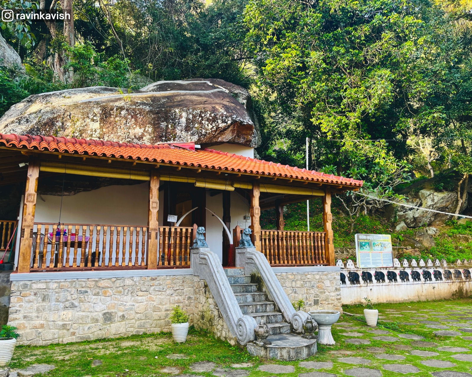 Historic image house at Ravana Royal Temple near Ella, featuring a terrace garden, natural rock formations, and lush forest surroundings.
