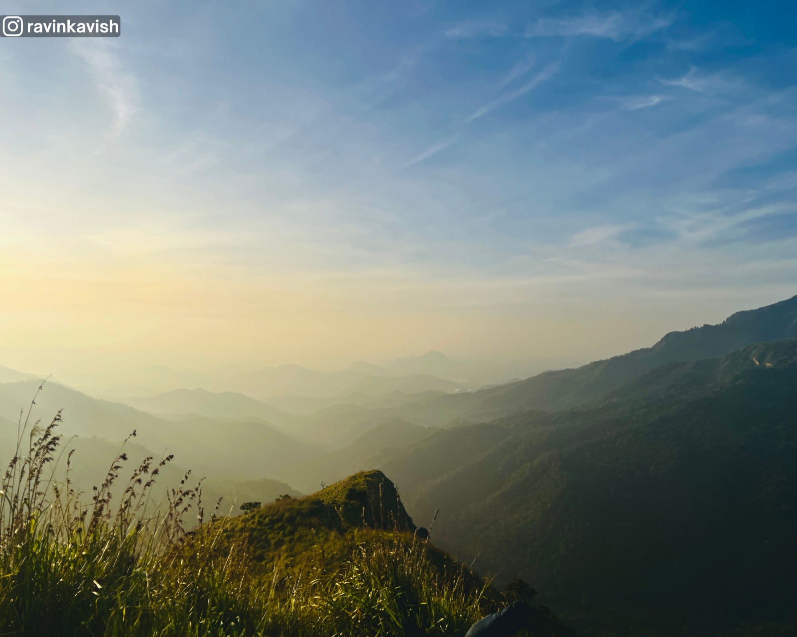Morning glow view from the summit of Little Adams Peak in Ella with distant mountains showcasing Sri Lankas scenic hill country