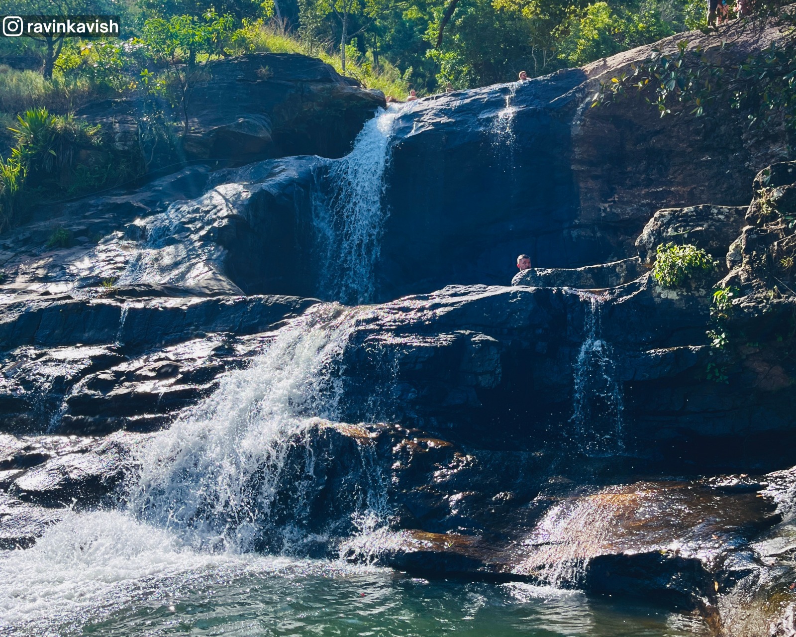 Short waterfall along the stream of Upper Diyaluma Falls, surrounded by rocks and greenery
