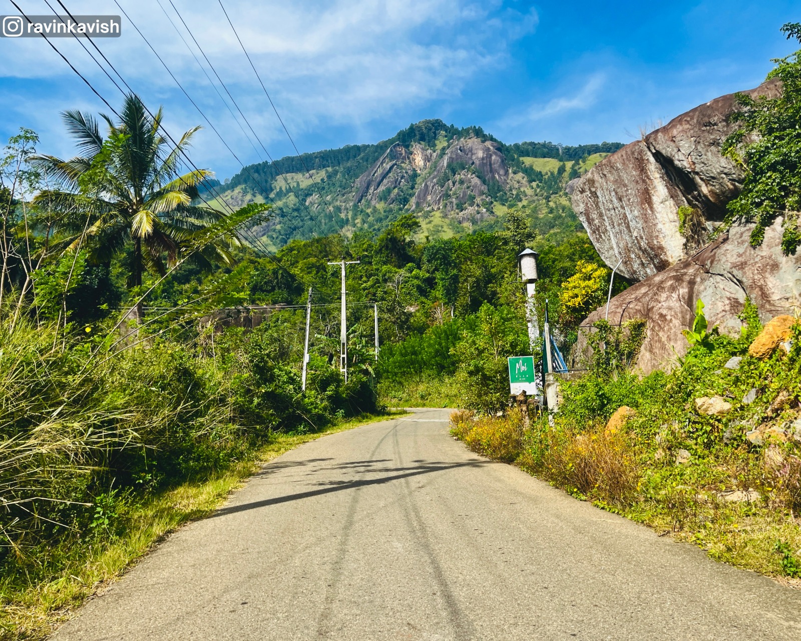 View of Kurullangala mountain ahead from the road on the way to Rakkiththa Kanda Rajamaha Viharaya, with surrounding greenery