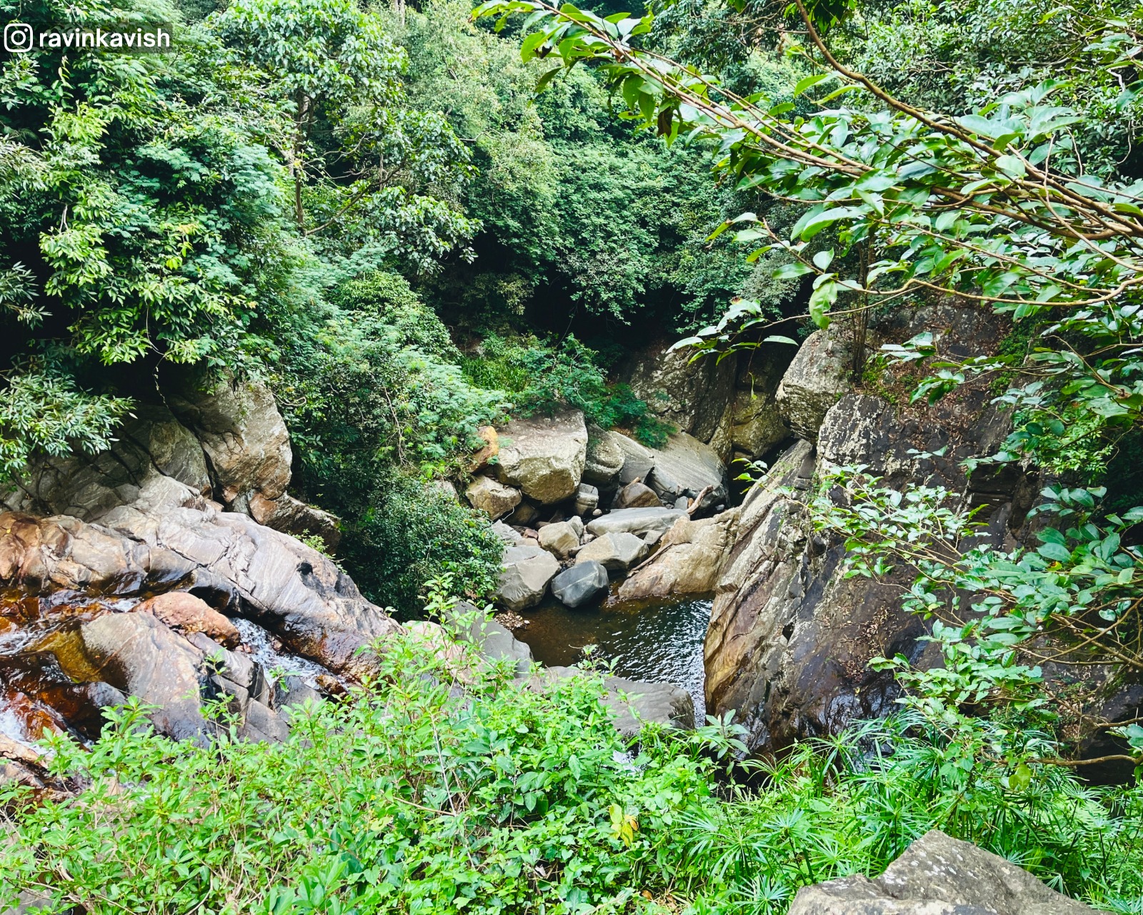 Water flowing through layered rocks below Visari waterfall with a sense of depth and surrounding nature near Ella showcasing Sri Lankas natural landscapes
