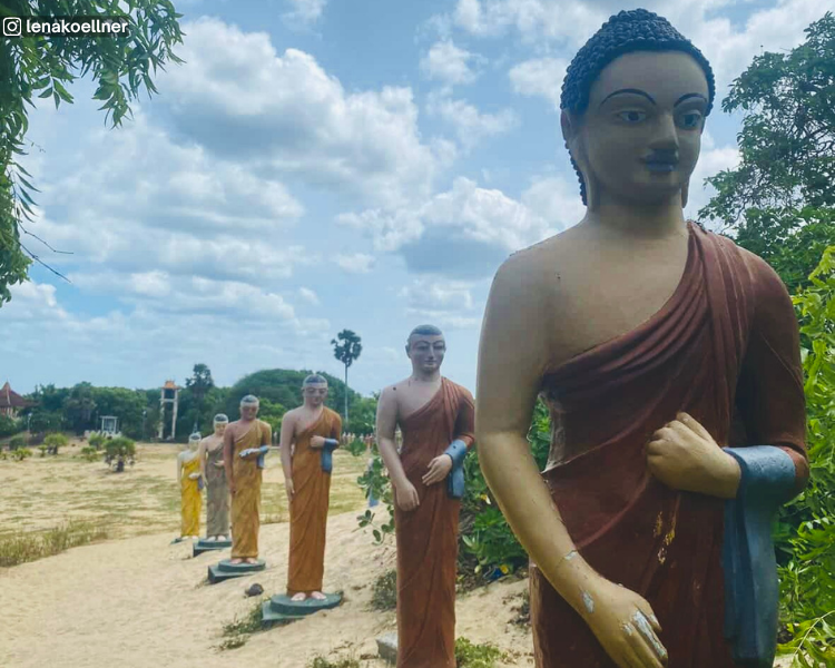 Line of Buddha and monk statues in the sand at Muhudu Maha Viharaya near Pottuvil, Sri Lanka