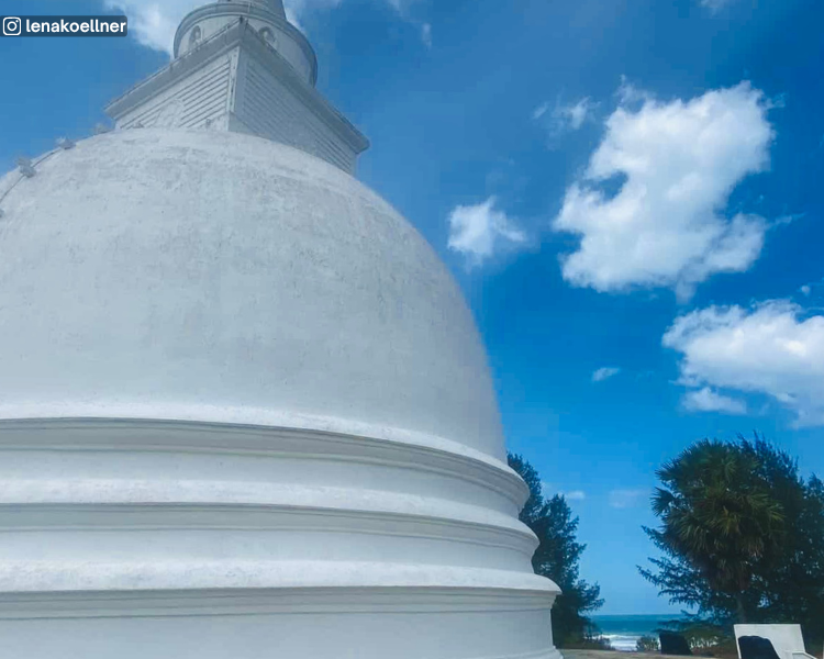 Stupa at Muhudu Maha Viharaya with a glimpse of the sea through two trees, near Pottuvil, Sri Lanka