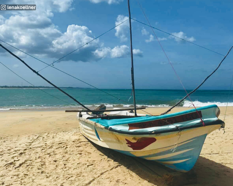 Fishing boat on the beach with sea and horizon at Peanut Farm Beach near Arugam Bay, Sri Lanka
