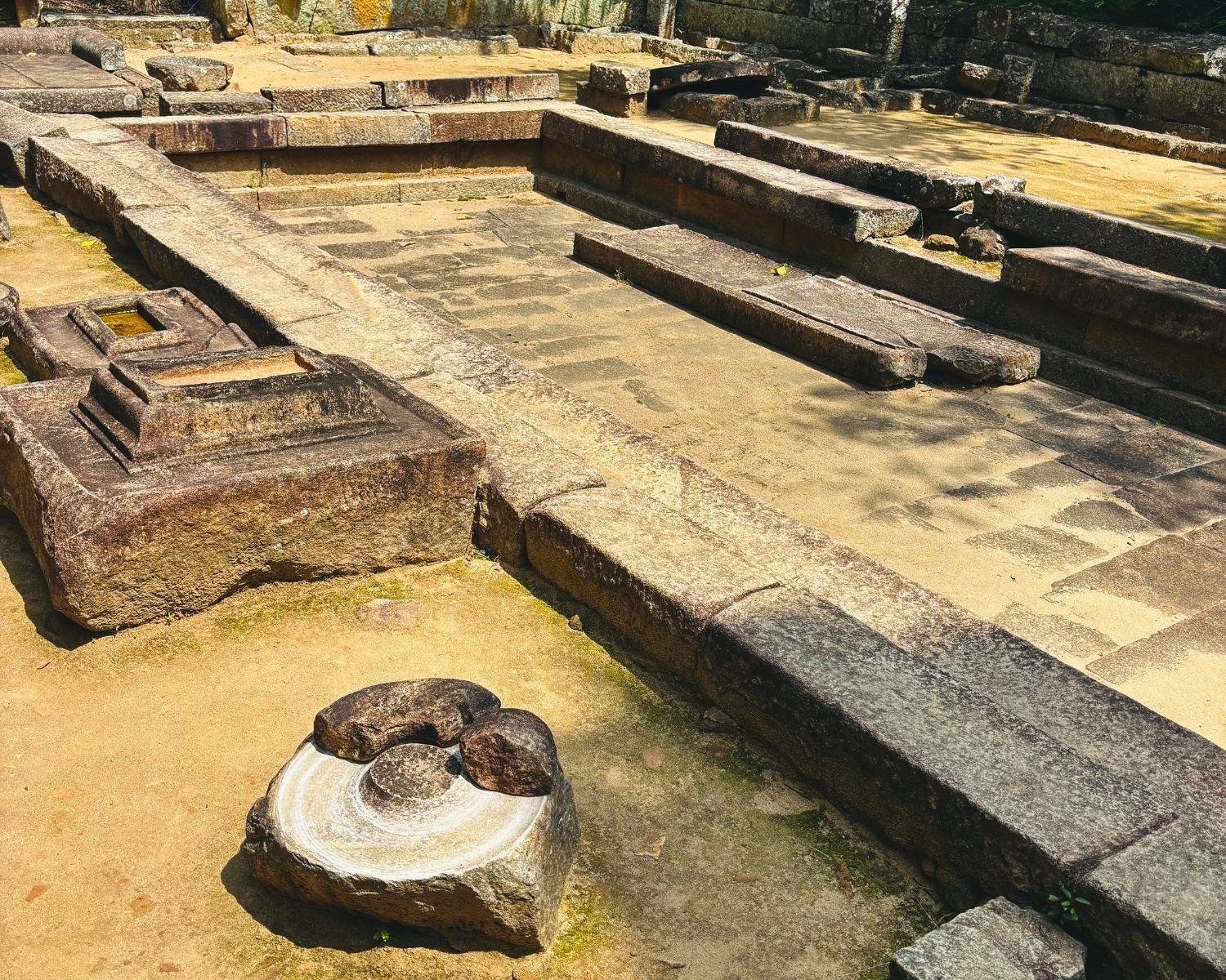 Stone grinding mortar and sunken bathing area at the Janthaghara ancient hospital ruins, Ritigala Archaeological Reserve near Habarana, Sigiriya, Sri Lanka