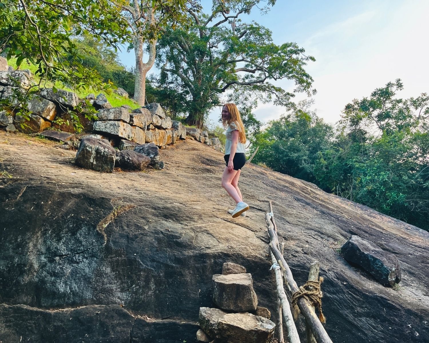 Stone steps with handrail leading to mid-tier summit plateau at Mapagala Fortress Little Pidurangala with ancient stone wall Sri Lanka