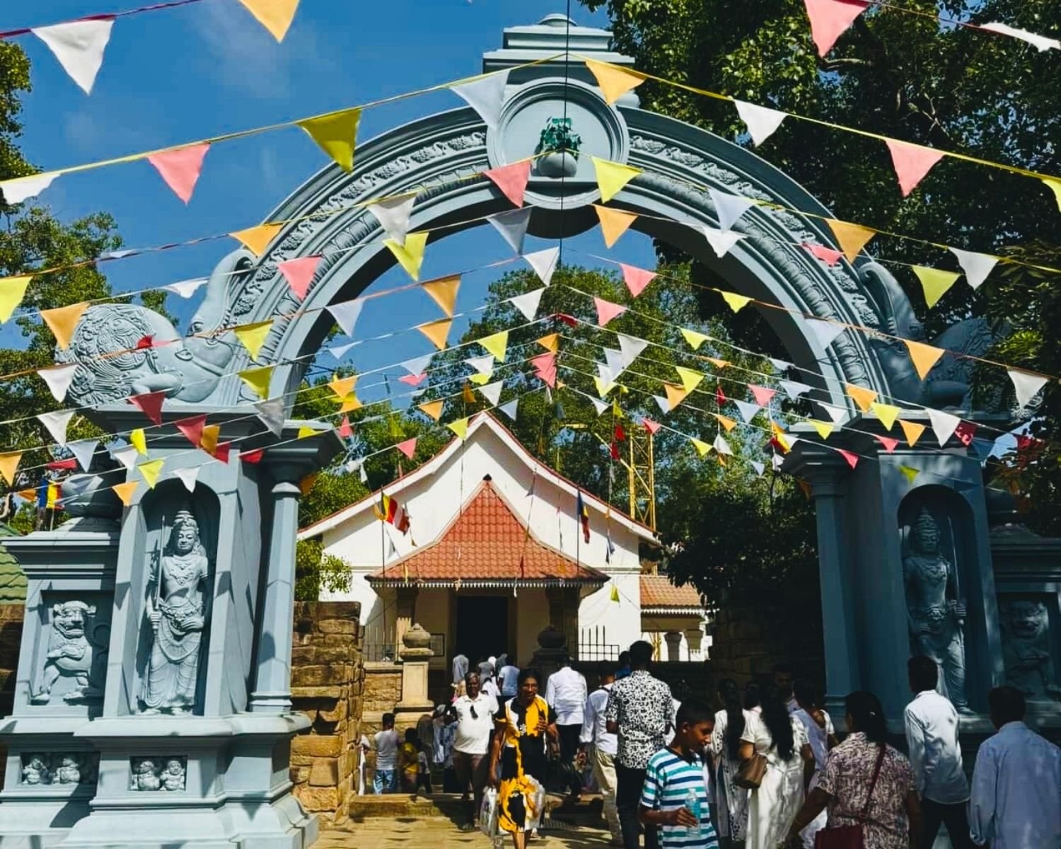 Makara Torana gateway with guardian deities and festival bunting at Jaya Sri Maha Bodhi premises in Anuradhapura