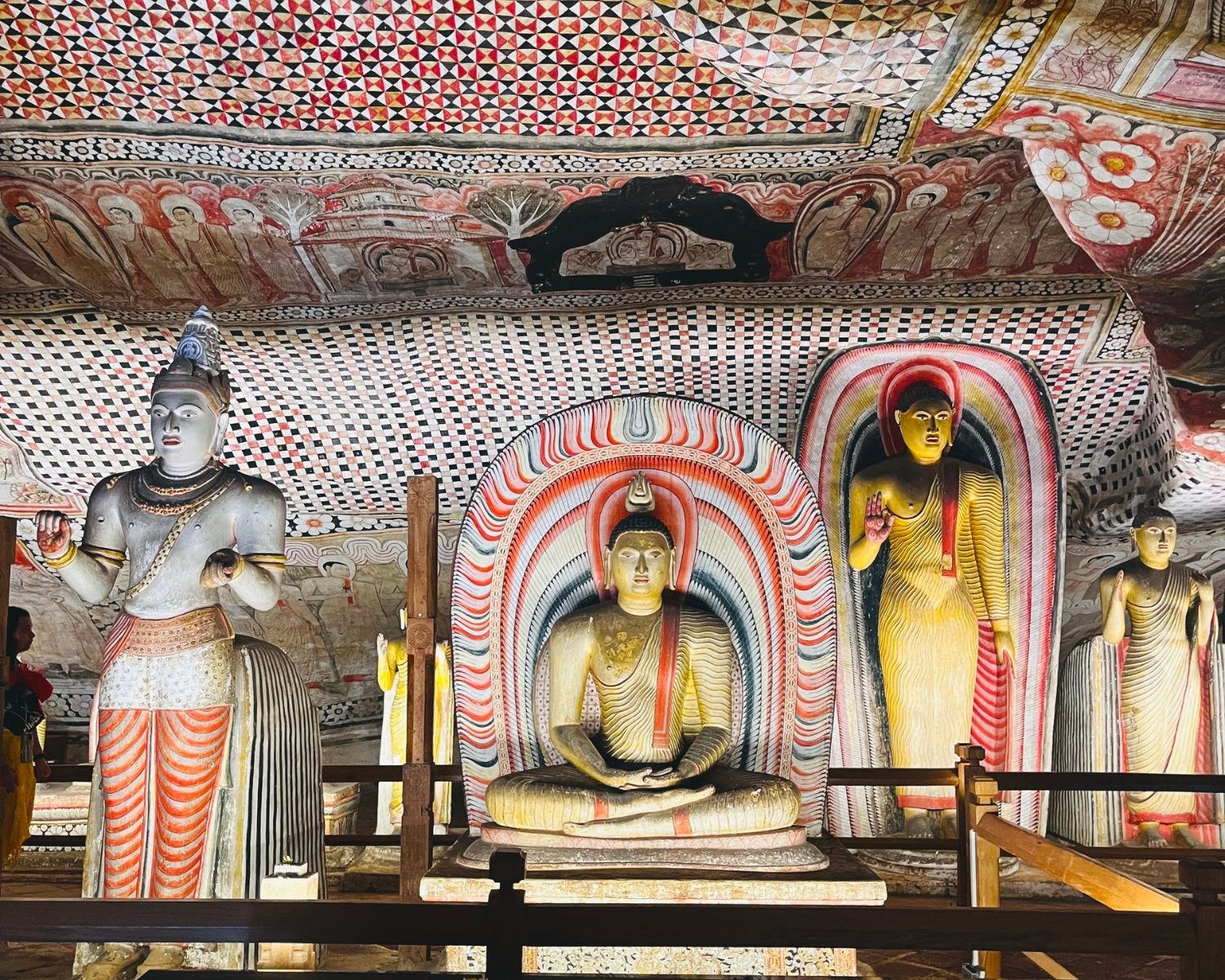 Natha deity statue beside seated and standing Buddha statues