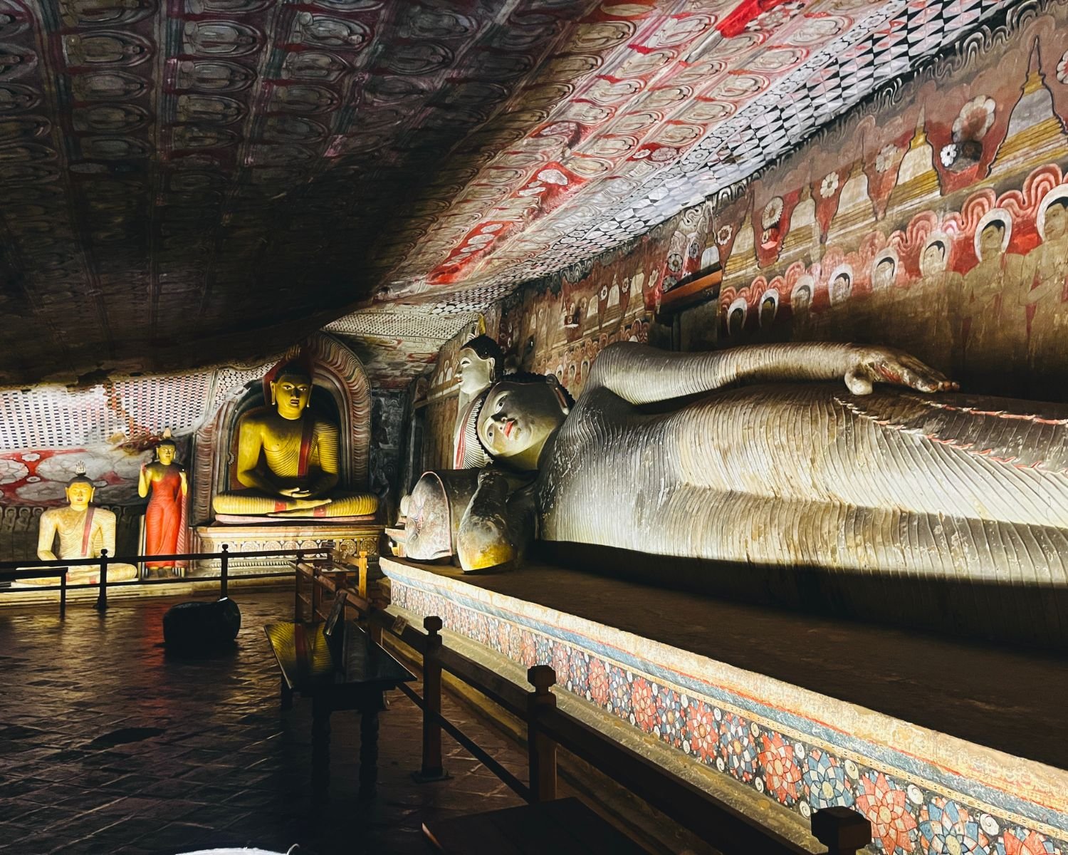 Reclining Buddha statue with seated Buddha images and painted cave murals
