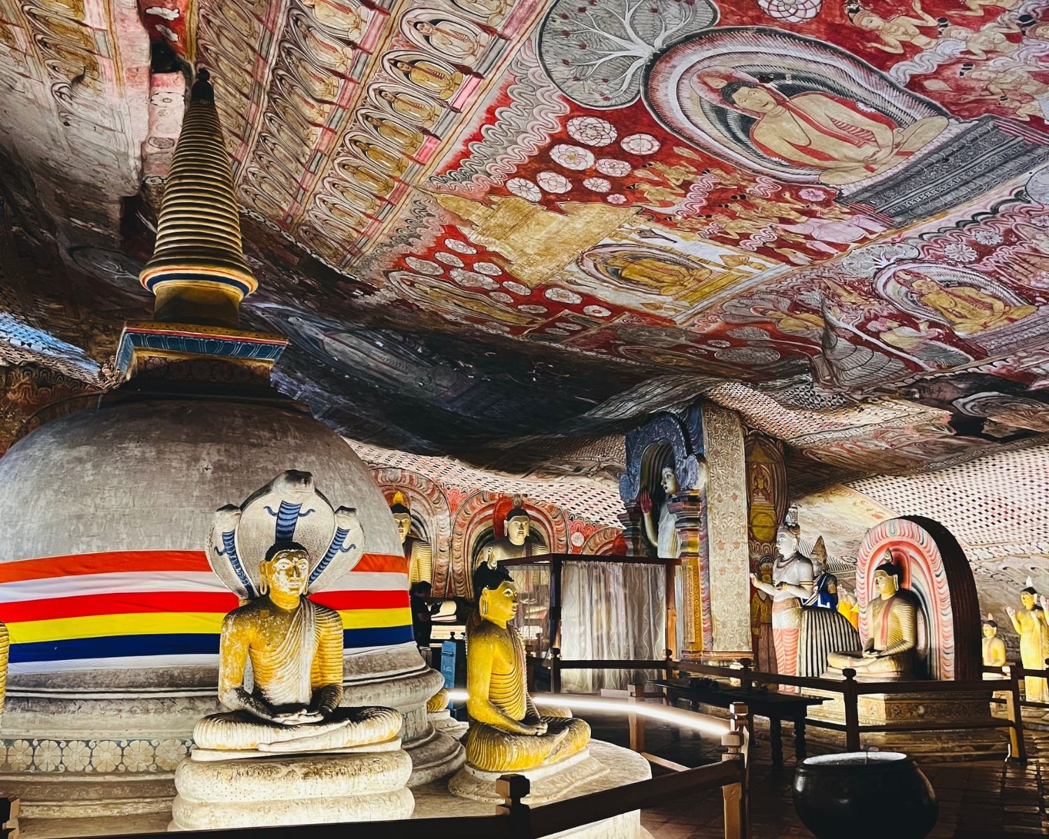 Maharaja Viharaya Cave 2 showing a large stupa, Naga Buddha statue, seated Buddhas, and painted ceiling murals