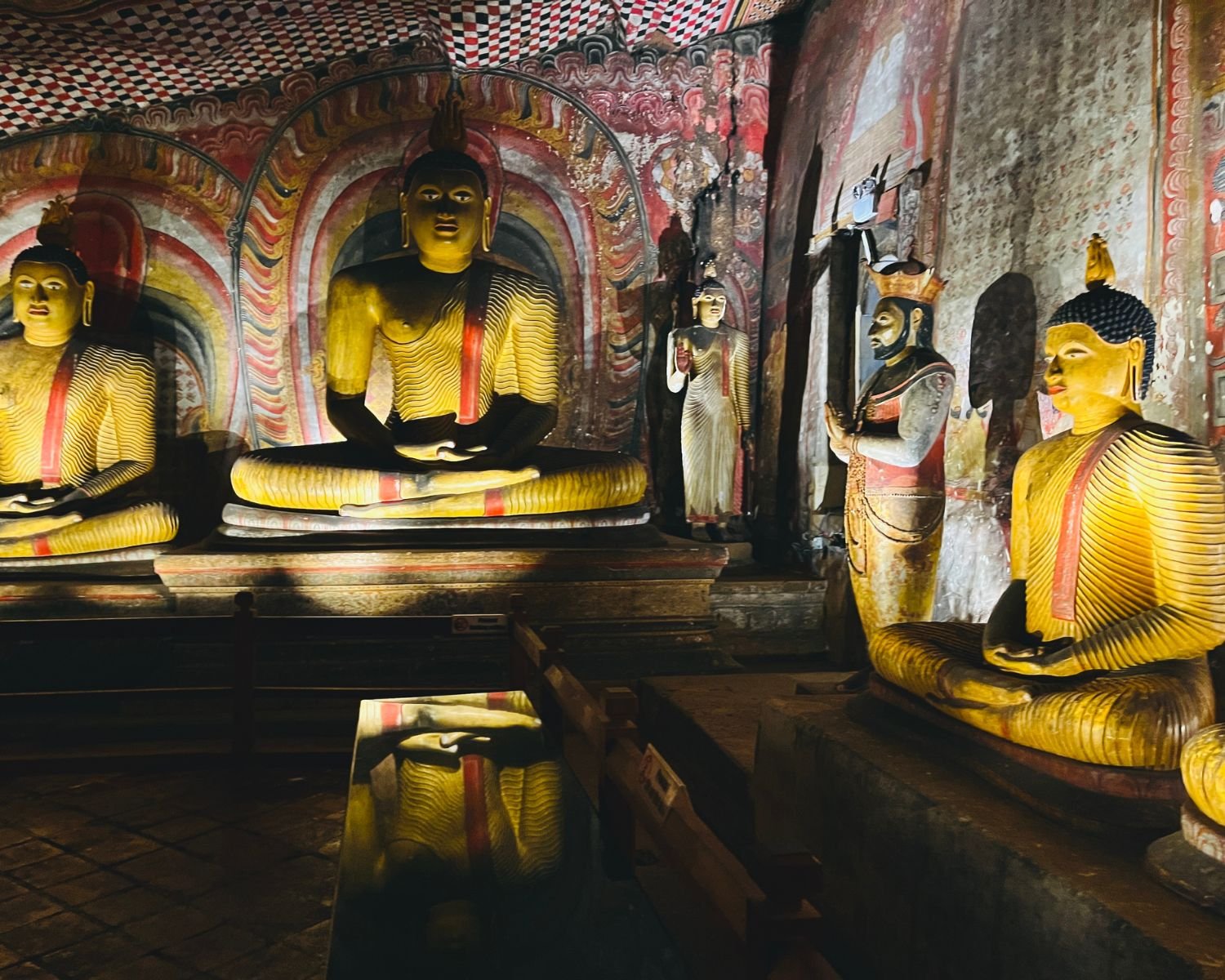 King Kirti Sri Rajasinha statue beside seated Buddha statues