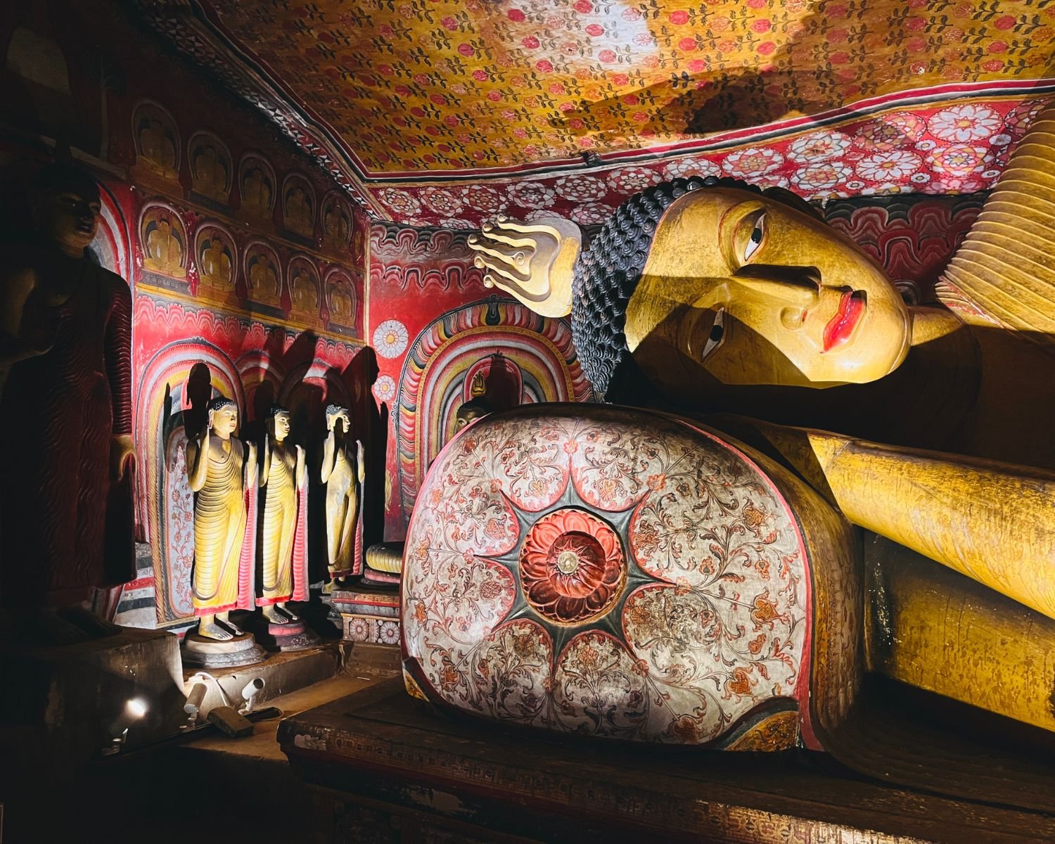 Reclining Buddha beside standing figures and Kandyan wall murals
