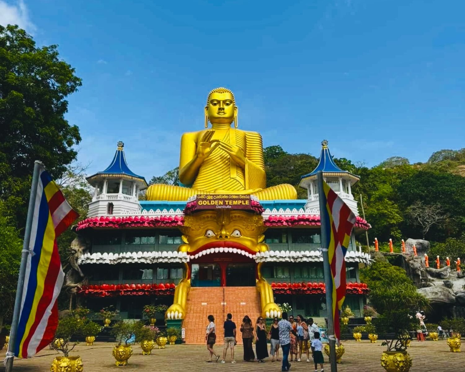 Giant golden Buddha above the colourful entrance building