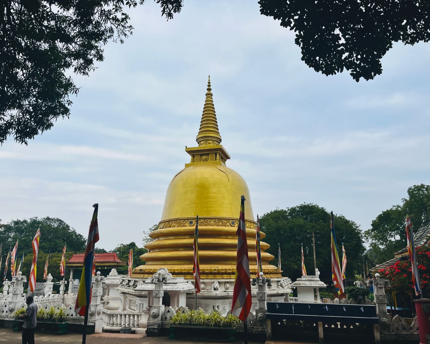 Golden stupa surrounded by Buddhist flags and trees