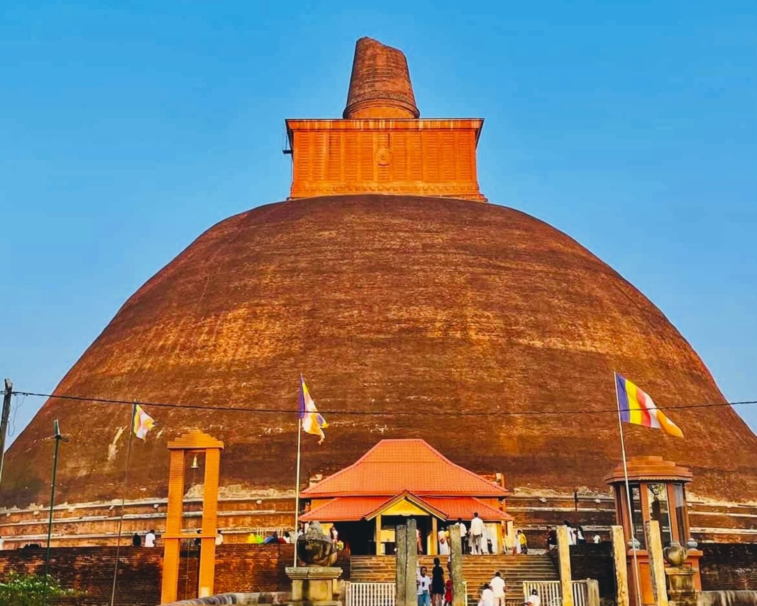 Jetavanaramaya stupa west entrance with exposed brick dome and broken spire under blue sky