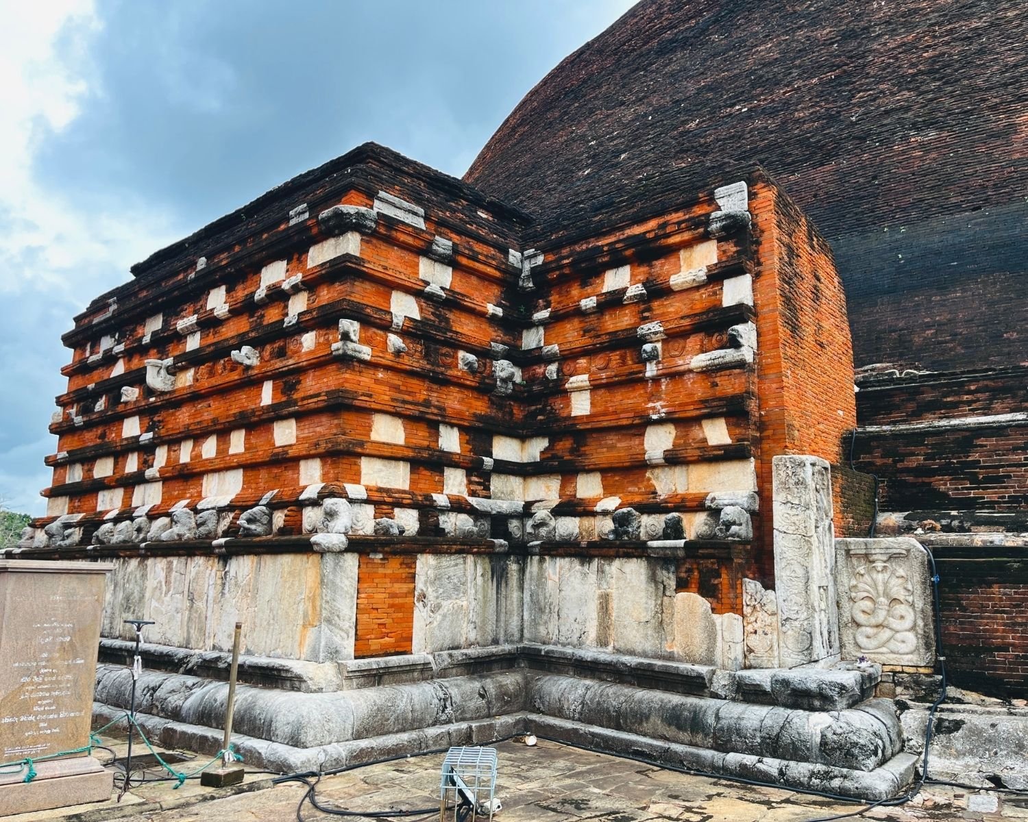 Jetavanaramaya west vahalkada with brick and limestone bands, stone carvings, and carved brackets beside brick stupa