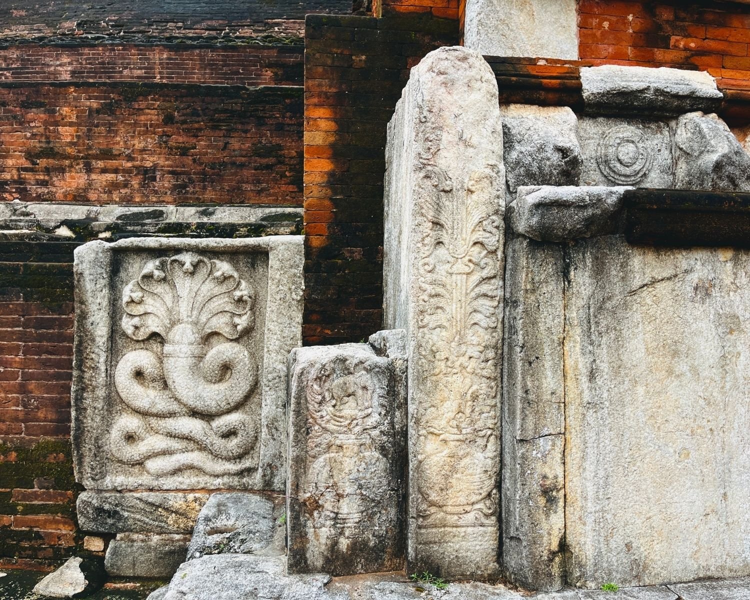 Jetavanaramaya west vahalkada with carved stone naga cobra and purnaghata vase of plenty against brick stupa