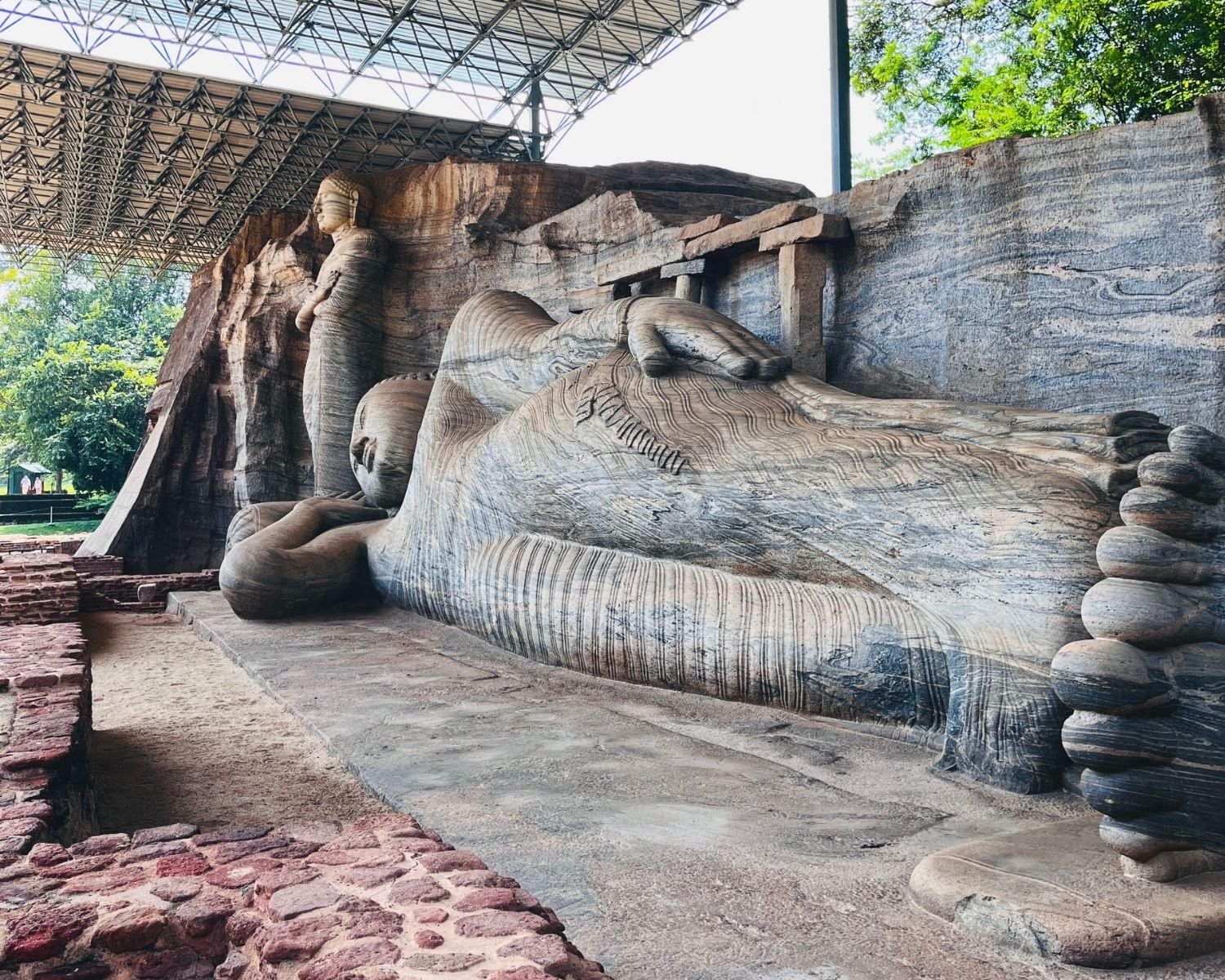 Side view of reclining Parinirvana Buddha with standing Buddha behind at Gal Vihara