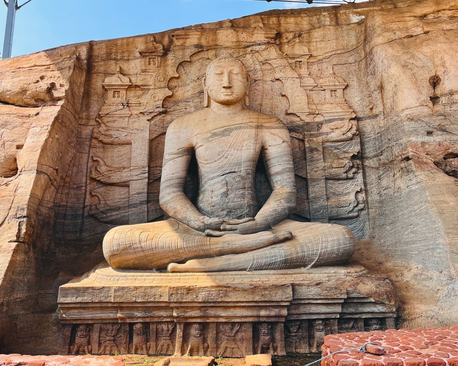 Seated Dhyana Buddha with lotus pedestal and carved throne panels at Gal Vihara