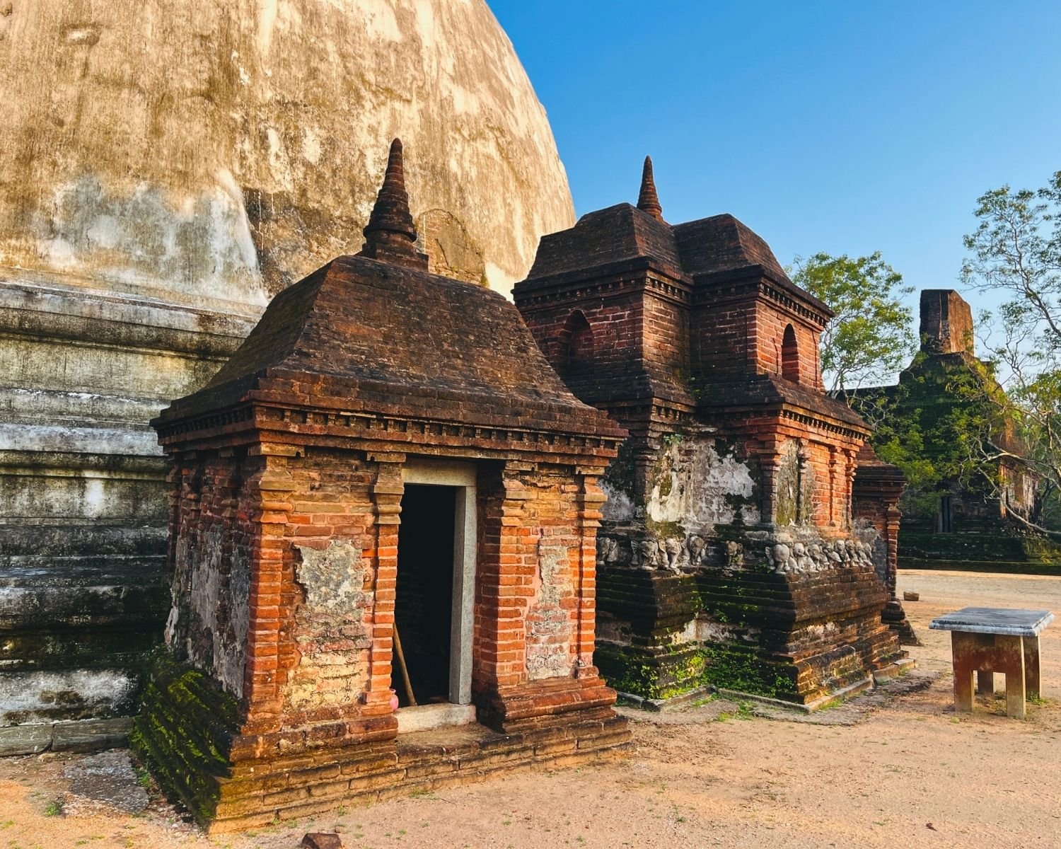 Brick vahalkada shrines with elephant frieze at base of Kiri Vehera dagoba with white dome rising behind