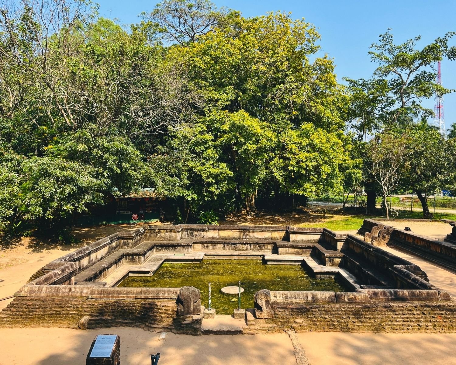 Front view of Kumara Pokuna royal bathing pond showing rectangular basin, stone walls, and central water feature