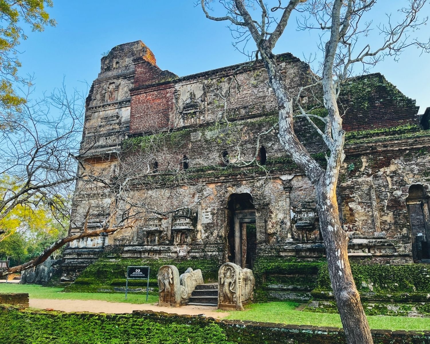 Wide view of Lankatilaka north wall with arched doorway, Sankha and Padma guardstones, and broken upper walls