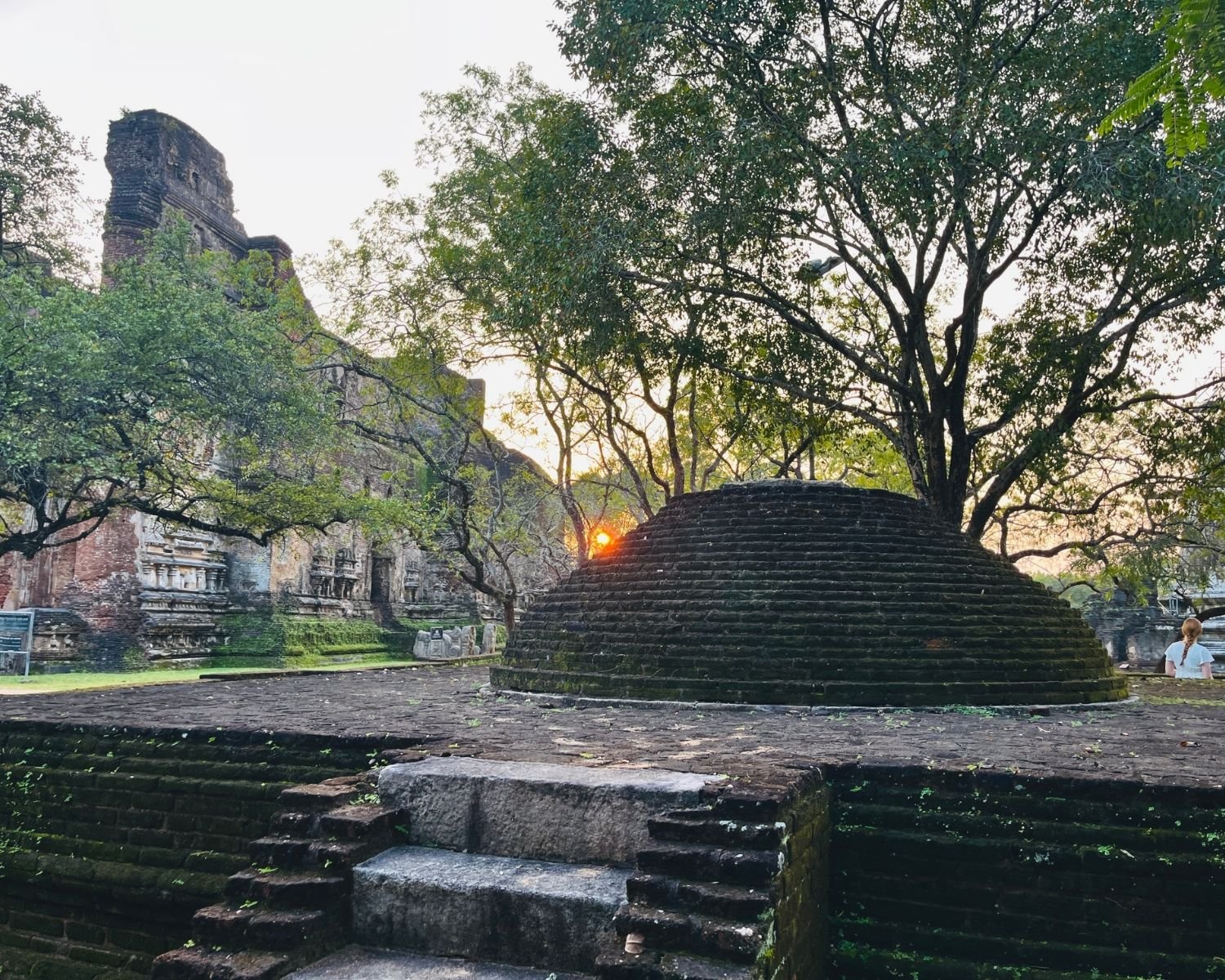 Small dome-shaped brick stupa on stone platform near Lankatilaka ruins at sunset in Alahana Pirivena