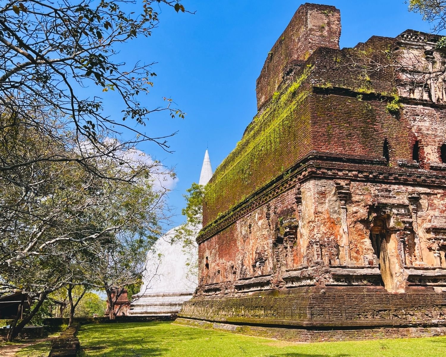 West wall of Lankatilaka with brick facade, arched opening, and Kiri Vehera stupa visible in background