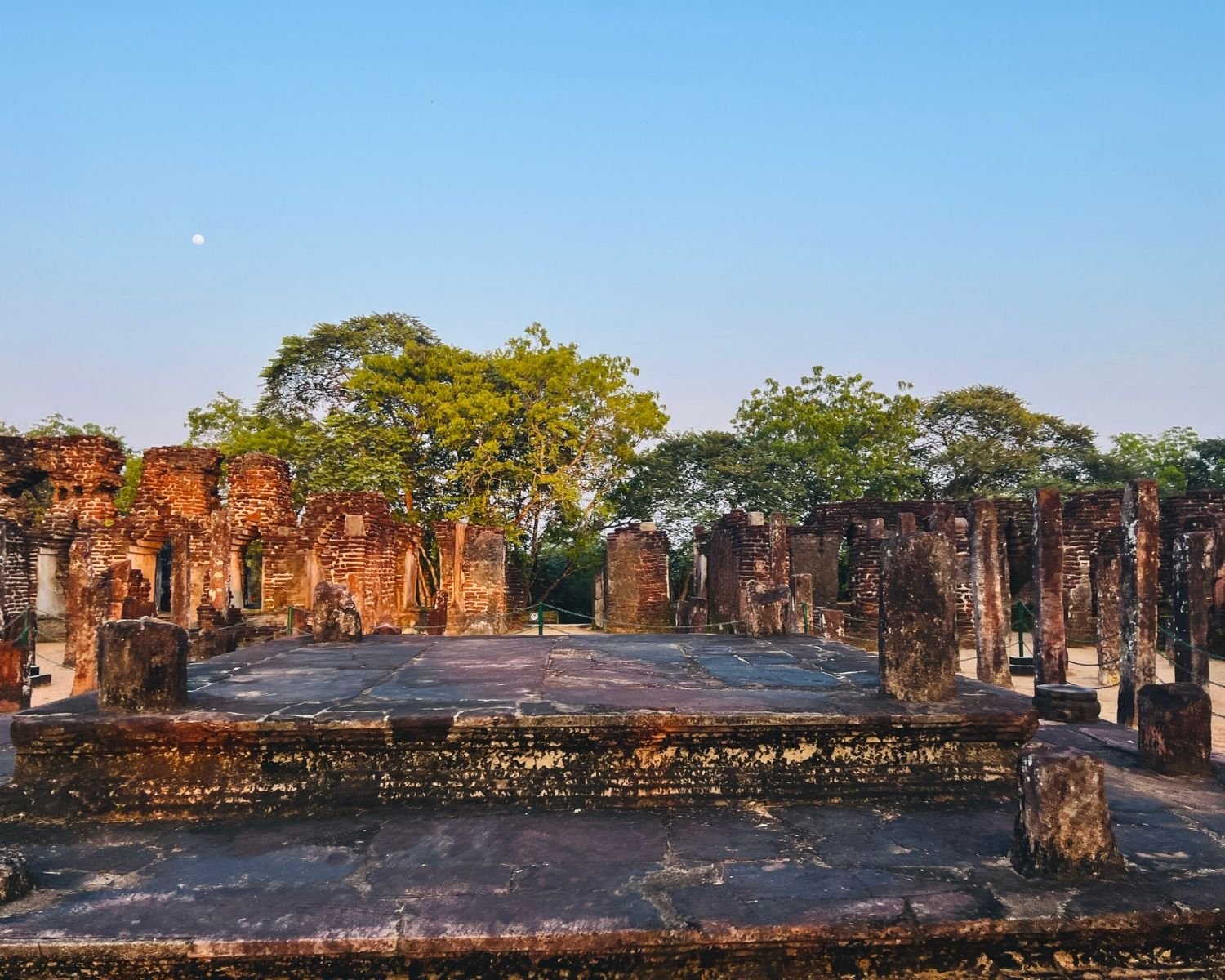 Interior stone platform inside Baddhasima Prasadaya with brick ruins and pillars at dusk