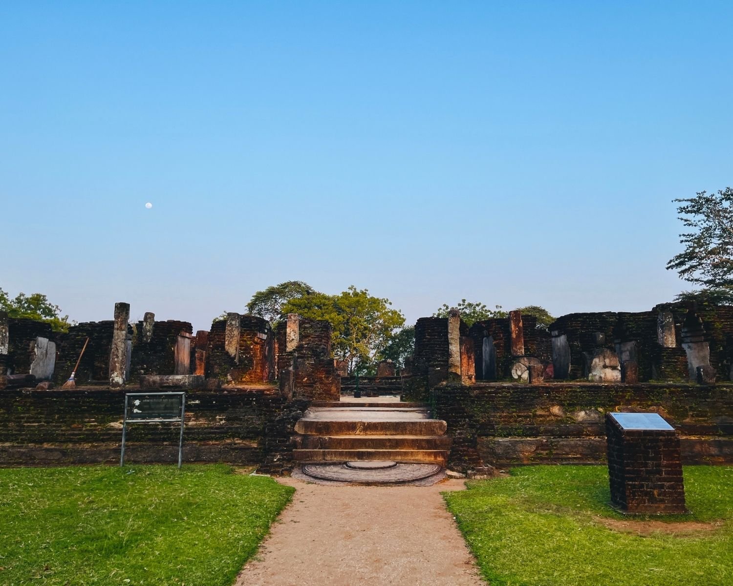 West face of Baddhasima Prasadaya with moonstone, steps, and pillars at dusk