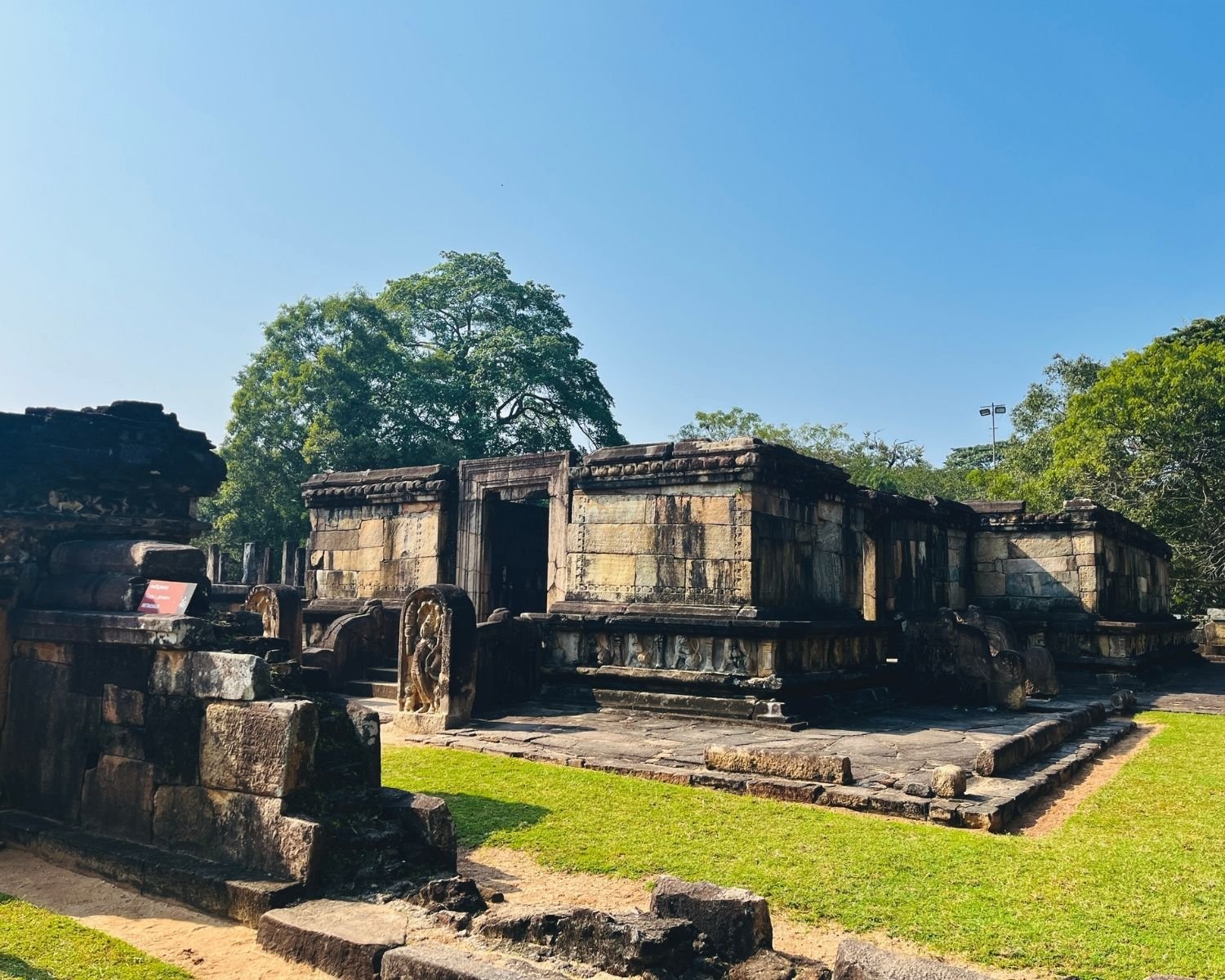 Front view of Hatadage relic house showing stone doorway, guard stone, and carved base