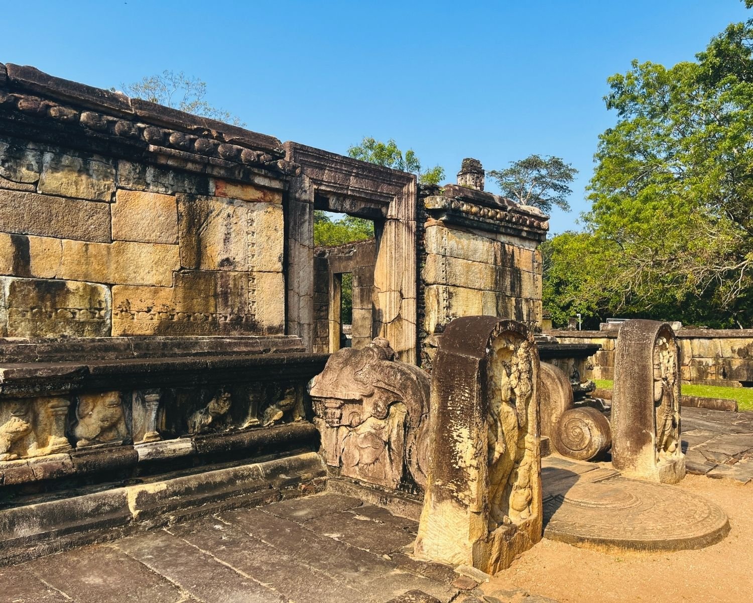 Side view of Hatadage showing stone walls, doorway, moonstone, and guard stones