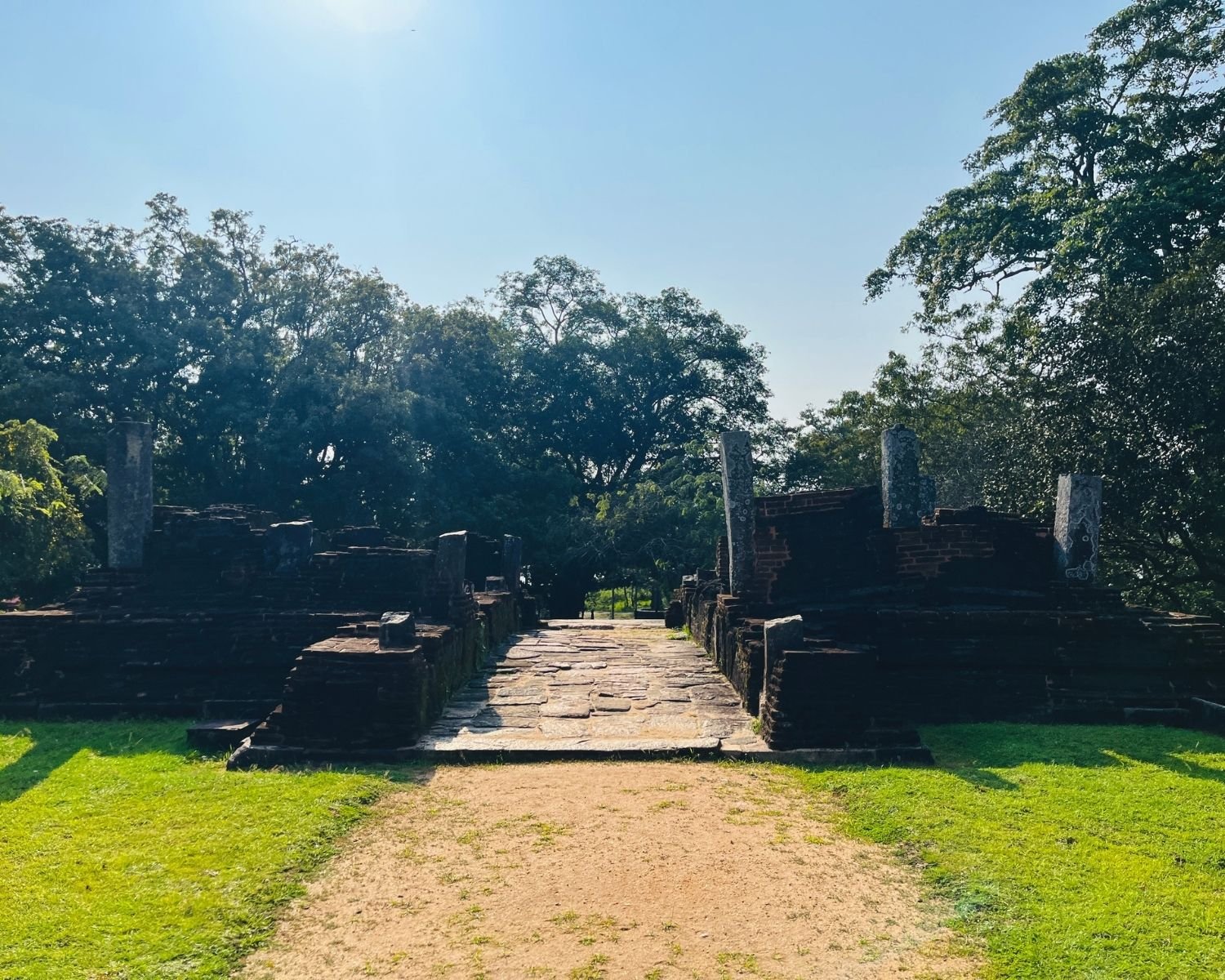 Stone gateway and brick ruins of western entrance to Sacred Quadrangle with carved pillars