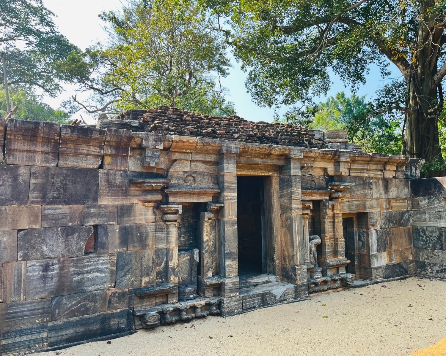 Close angled view of inner shrine at Shiva Devalaya No.1 with ornate doorway, stone carvings, and collapsed roof