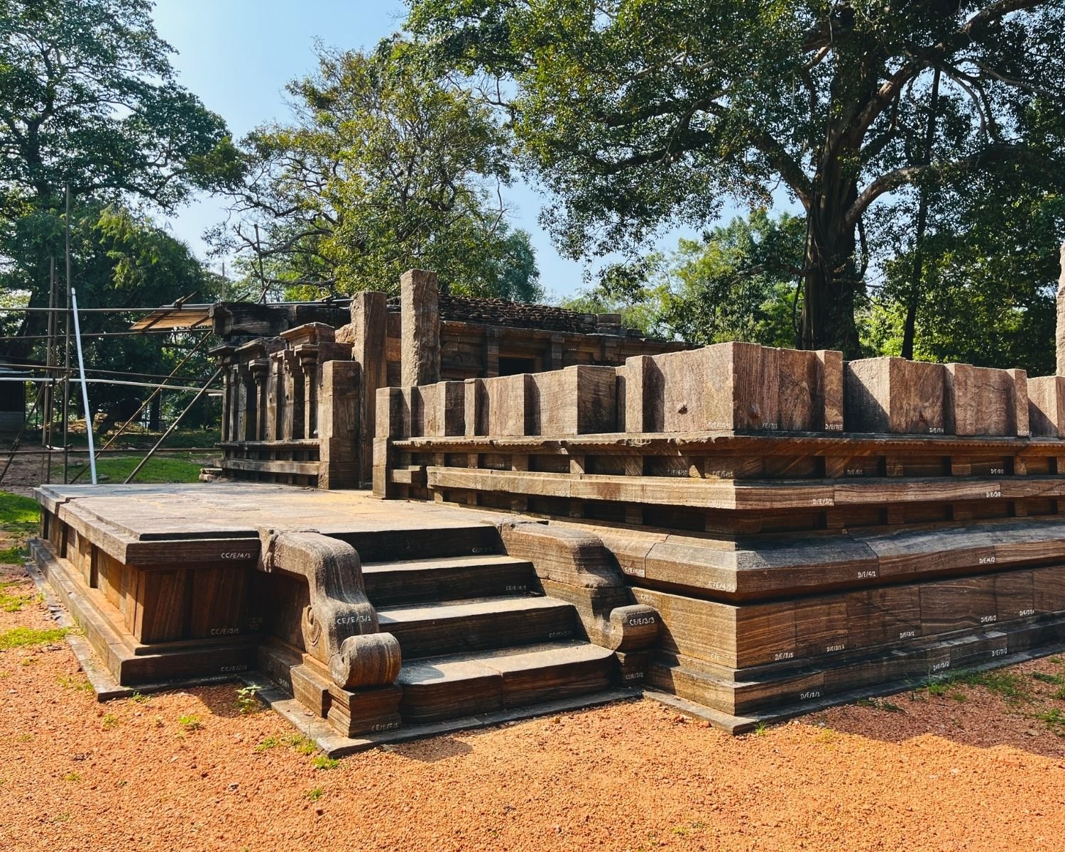 Side entrance of Shiva Devalaya No.1 featuring raised stone platform, carved balustrade steps, and tiered walls