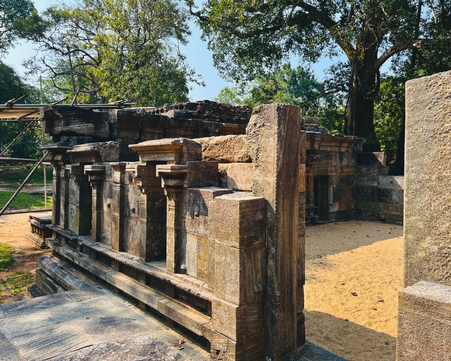 Side entrance of Shiva Devalaya No.1 showing tiered stone walls, detailed moldings, and stone paving
