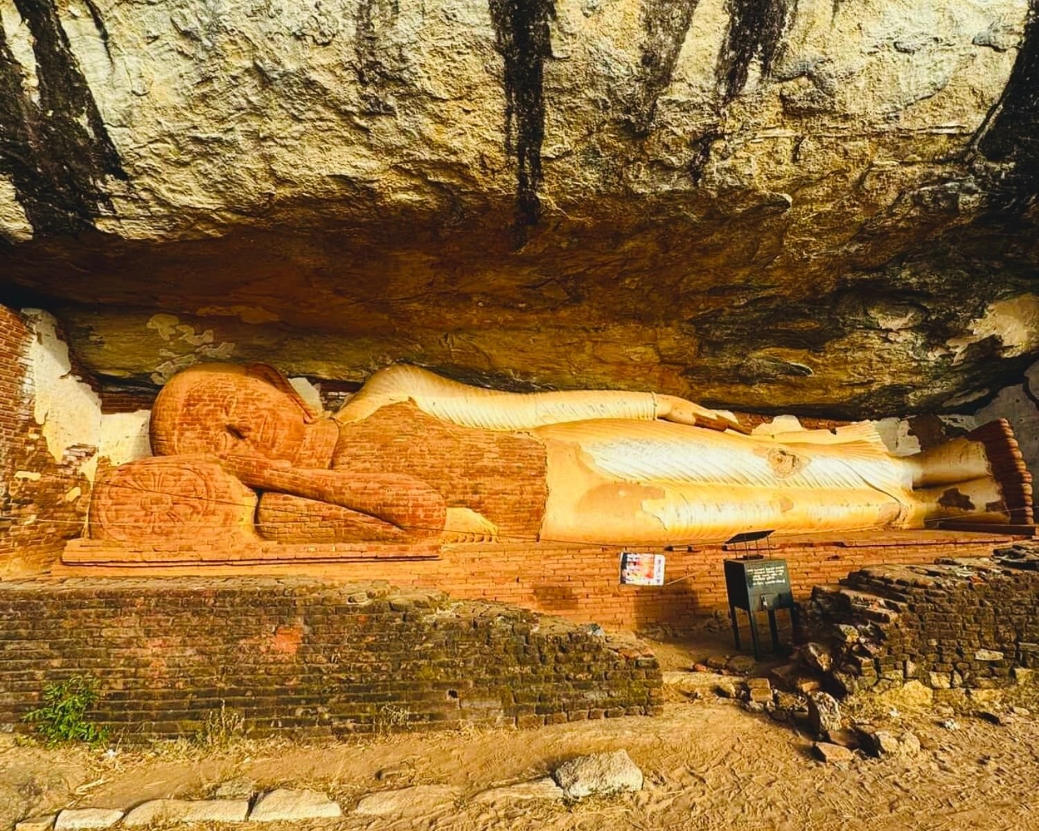 Reclining Buddha statue with yellow robes inside the shrine