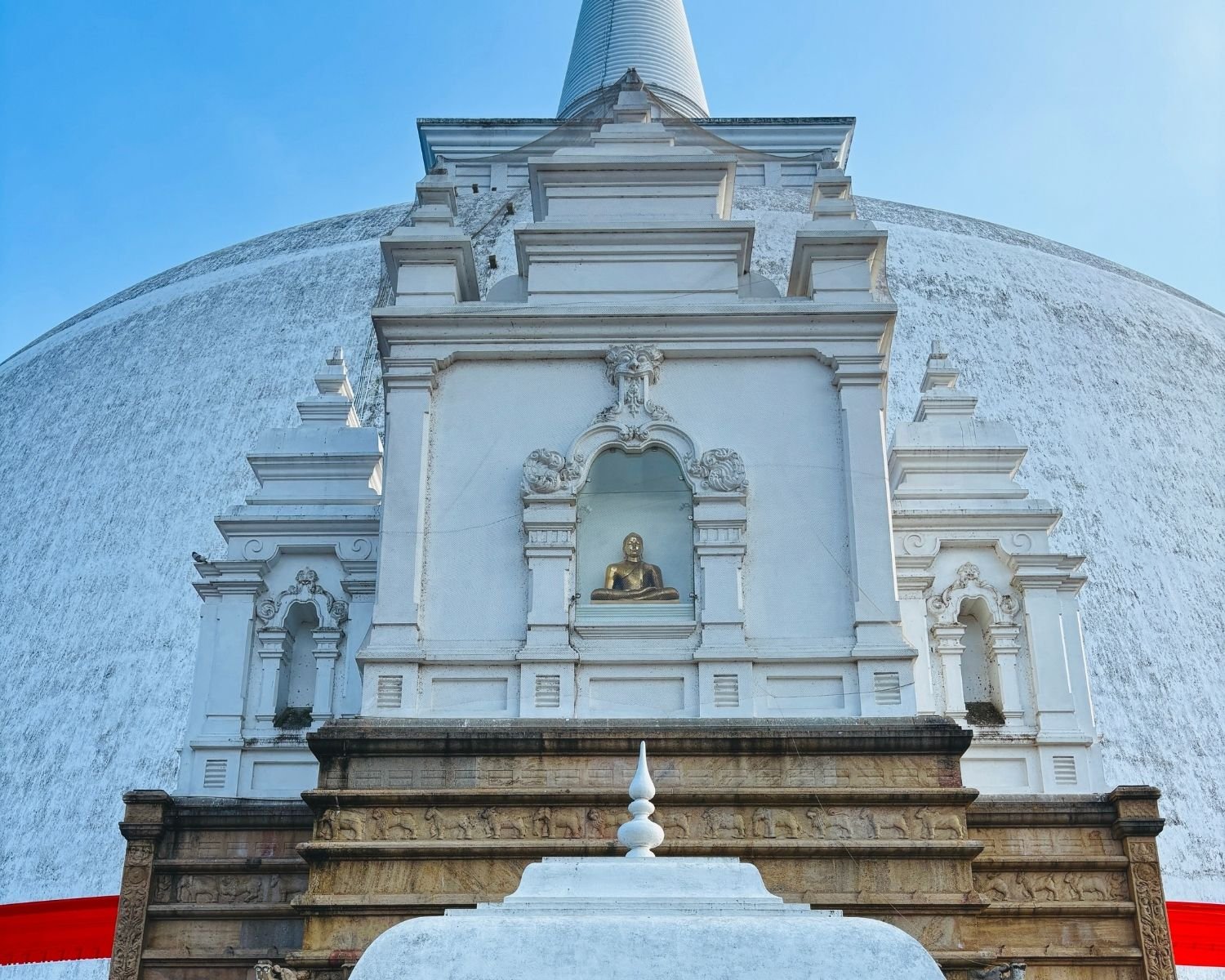 North vahalkada of Ruwanwelisaya stupa with golden Buddha statue and elephant frieze detail