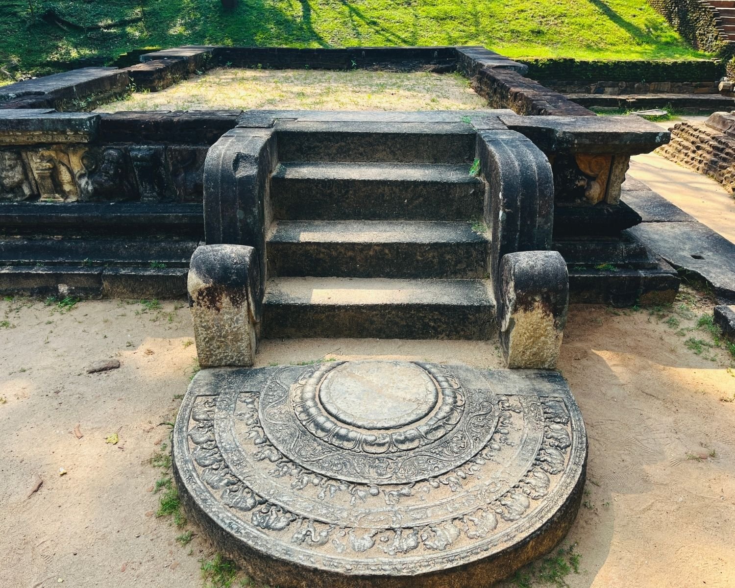 Raised stone platform with carved moonstone, steps, and balustrades near Kumara Pokuna