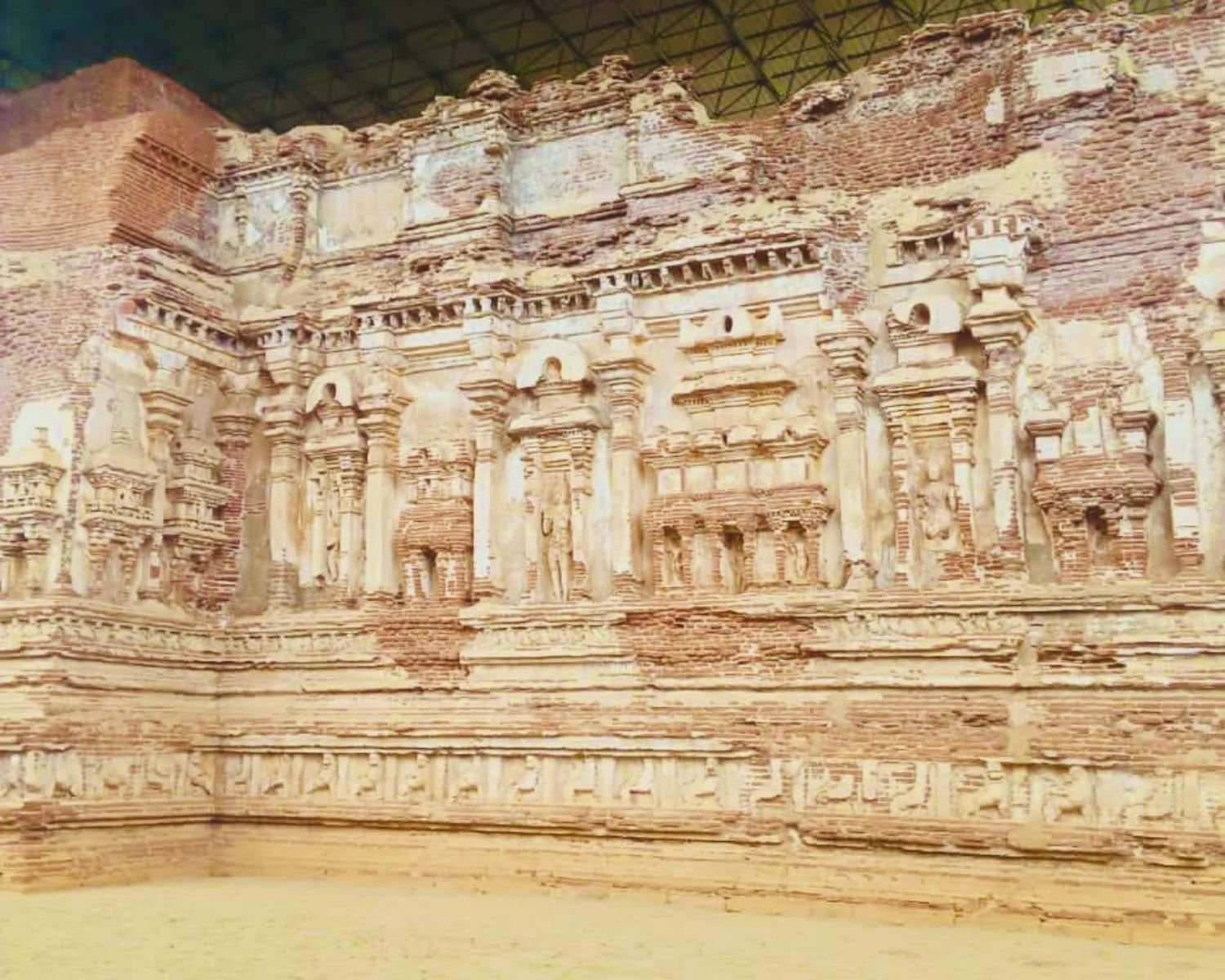 Exterior brick wall of Thivanka Image House with carved pilasters, niches, stucco figures, and lion frieze