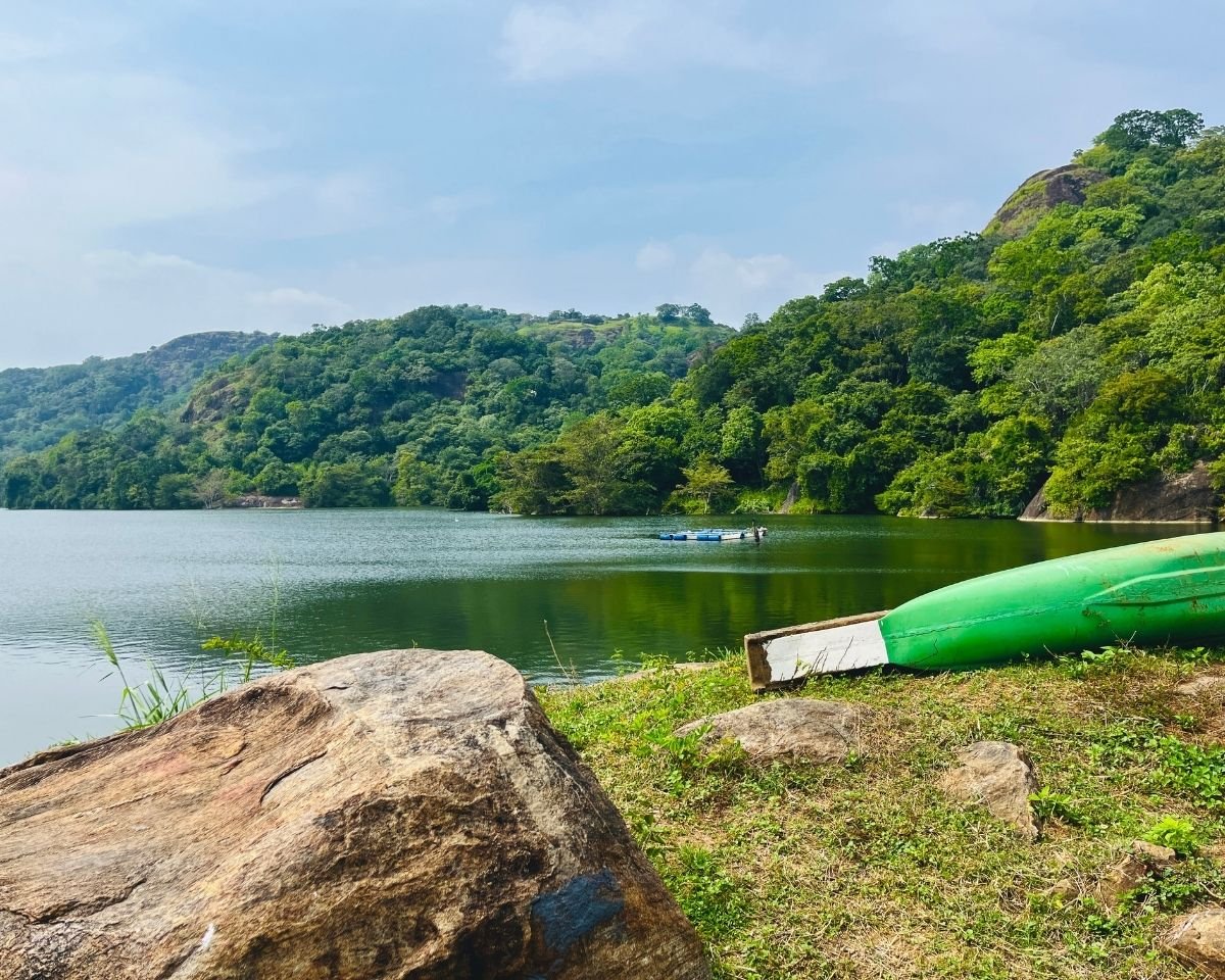 Wooden boat resting on the shoreline of Buduruwagala Reservoir